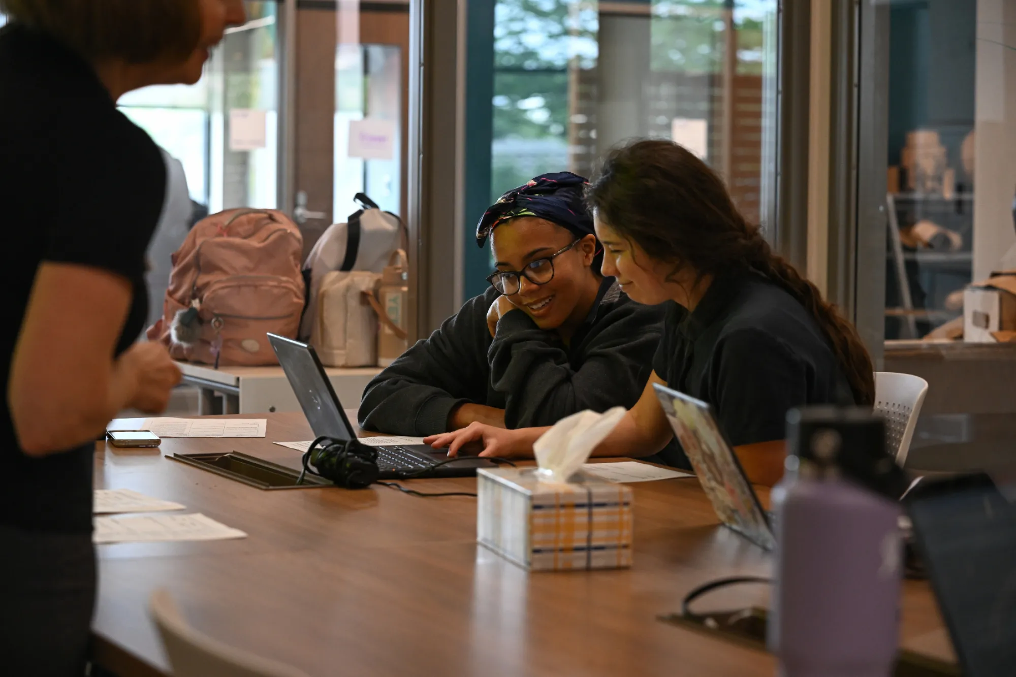 Two students work on a laptop together