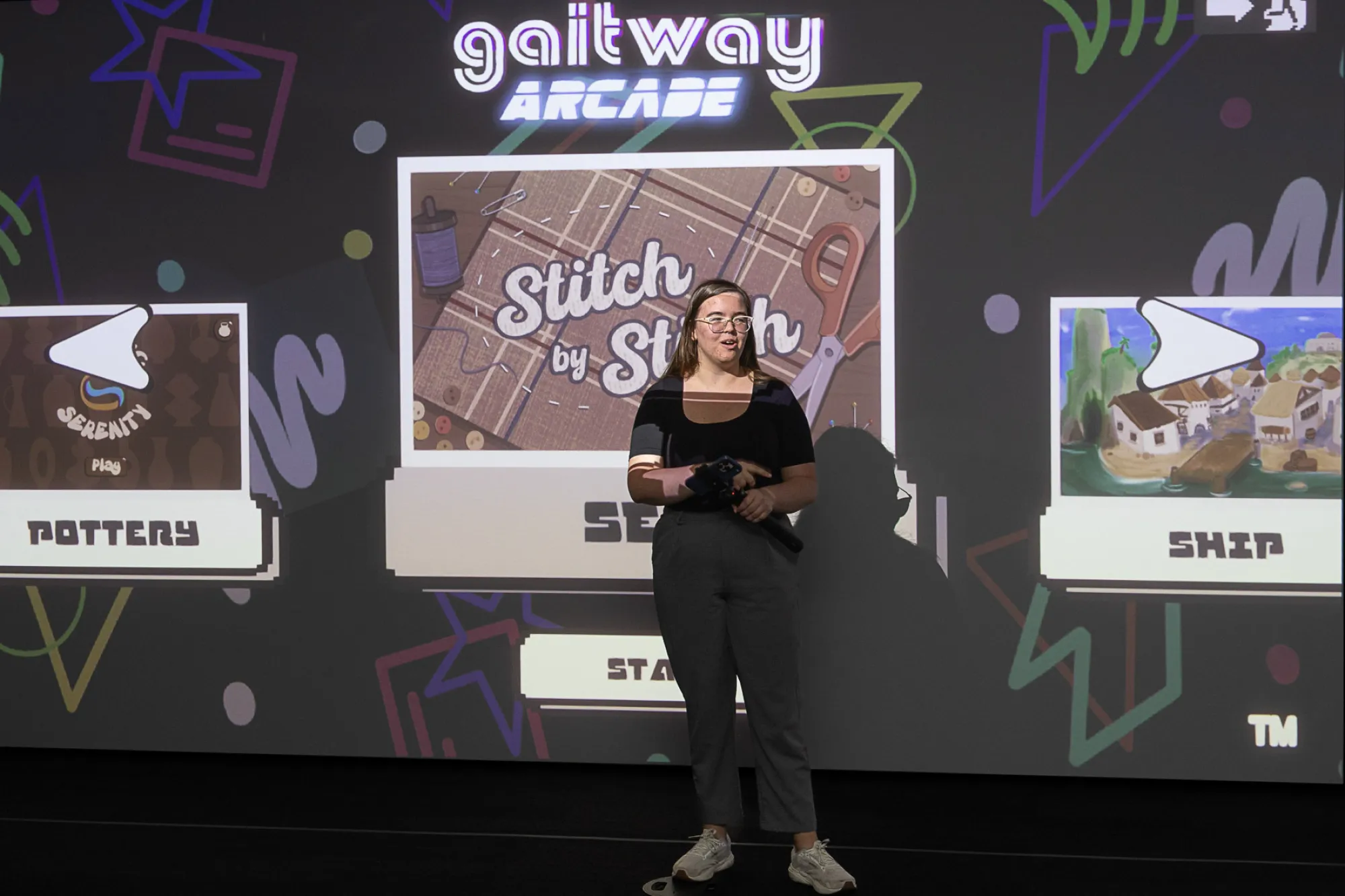 Ella Gault presents on a stage about the game she designed