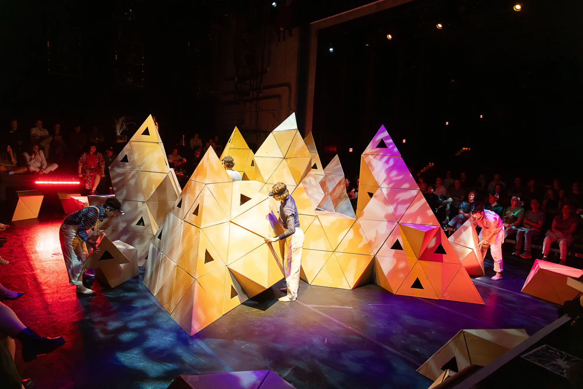A performer adjusts a cardboard mountain in the Rude Mechs' "Not Every Mountain" performance