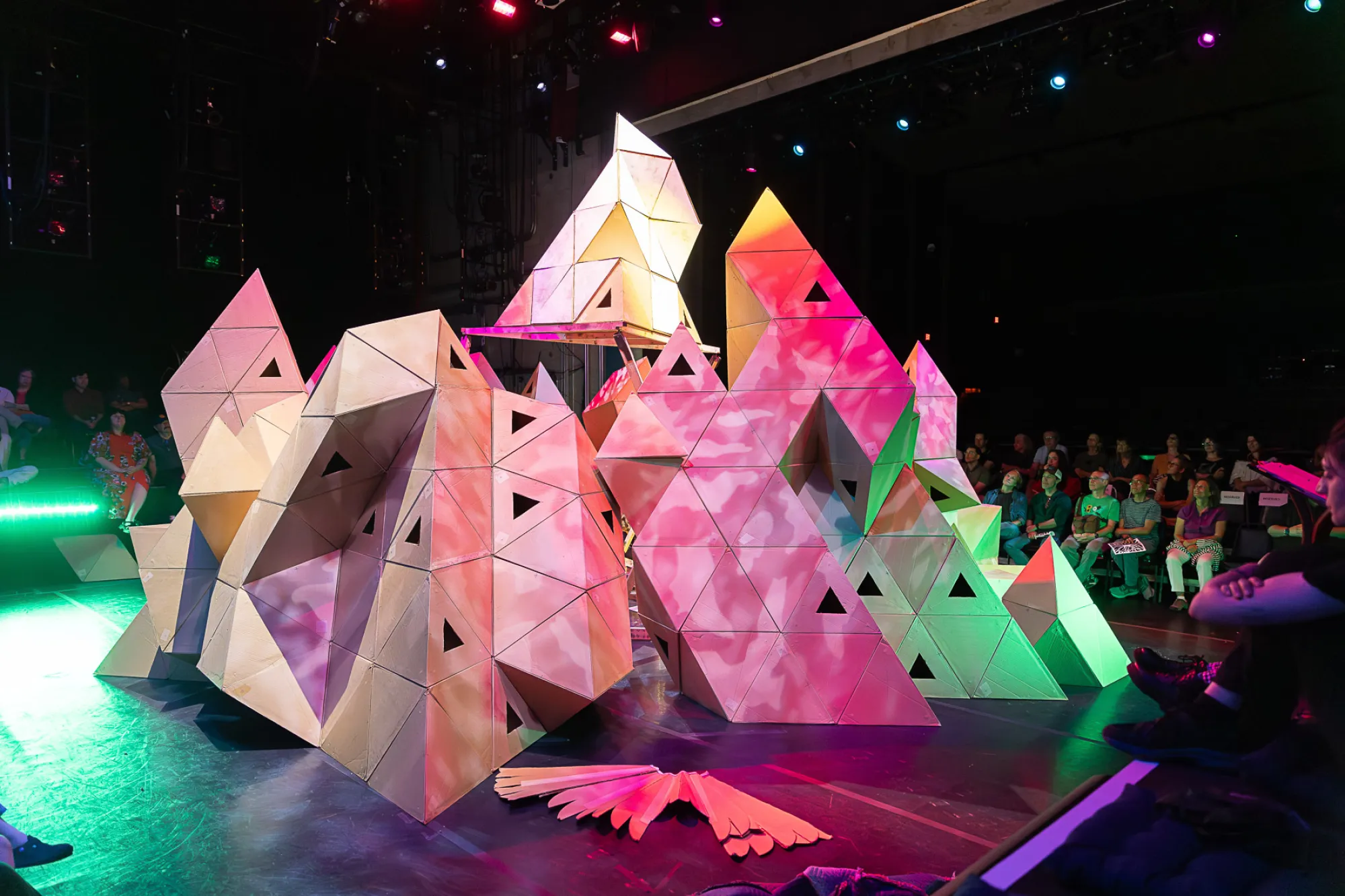 Cardboard mountains fill the stage in a Rude Mechs performance of "Not Every Mountain"