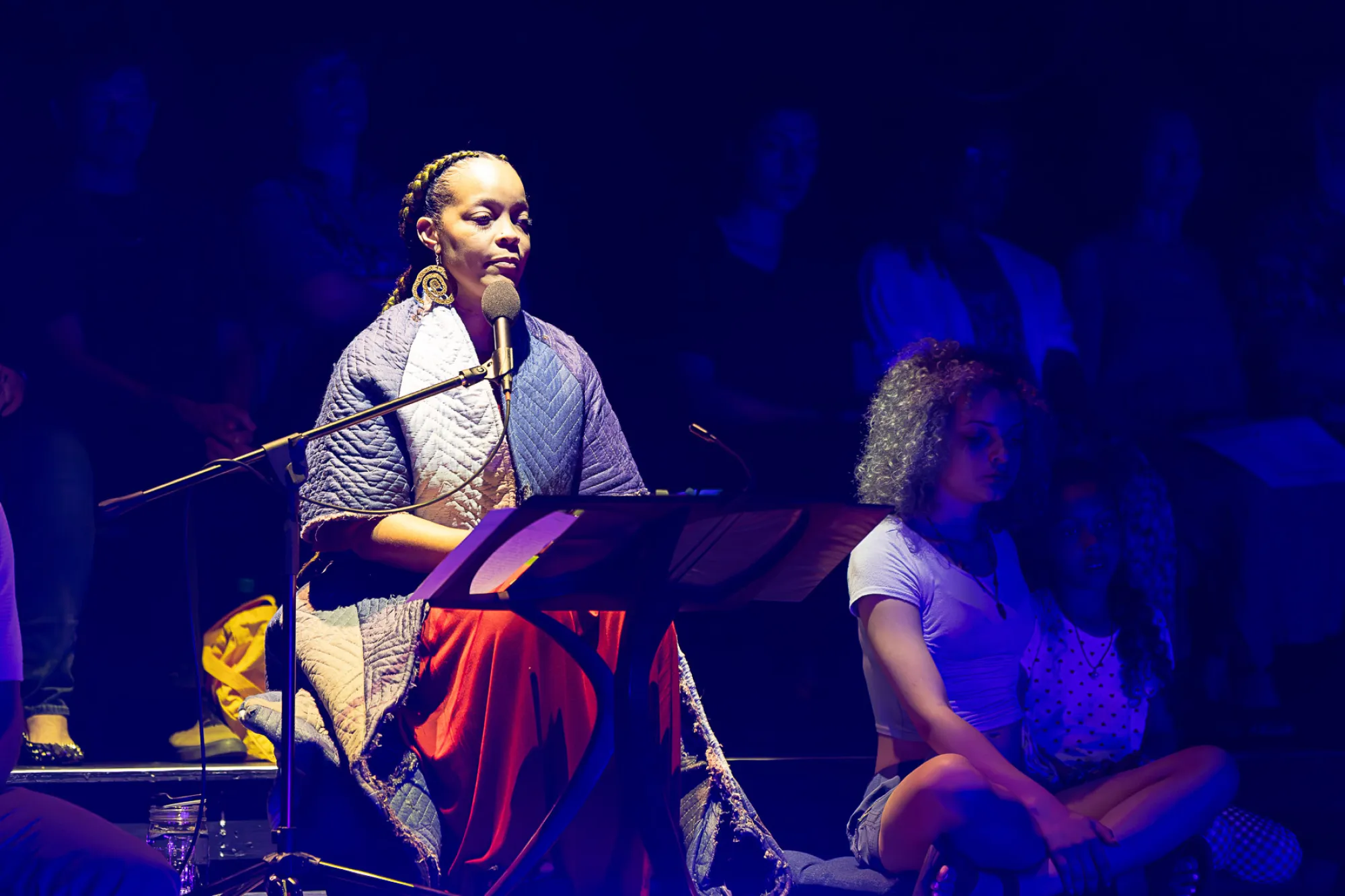 A narrator reads during a Rude Mechs performance of "Not Every Mountain"
