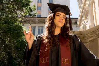 Si Mon' poses in front of the University Tower in her graduation gown for her graduation photo.