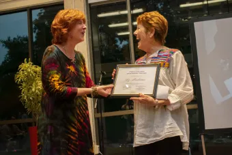 Christina Bain presents alumna Liz Abrahams with an award.