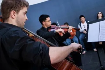 A cellist and violinist play to an audience in James Turrell's skyspace 