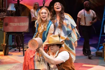 Three stage actors posed in a yelling or singing position