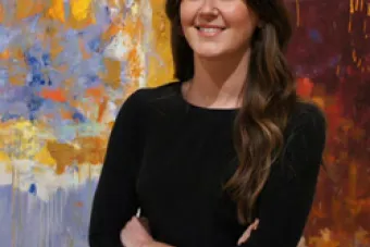 Callan Steinmann in front of an abstract art painting
