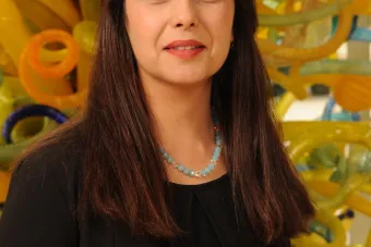 Roja Najafi stands in front of a work of art