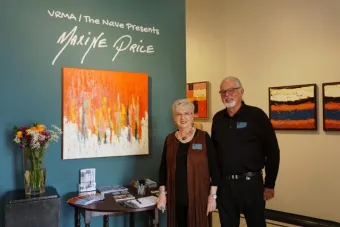 Maxine poses for a photo in front of her painting