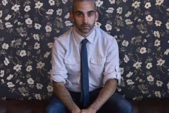 Michael Wellen sits in front of a floral wall