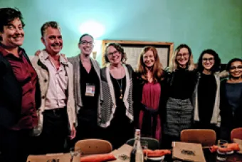 Group of faculty and alumni surrounding a table