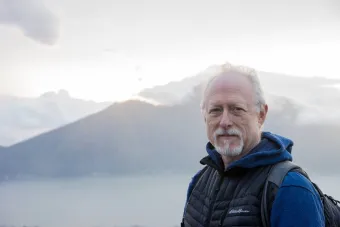 Robert Schenkkan stands on a mountain top