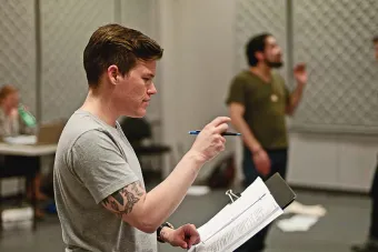 Will Davis holds papers while directing