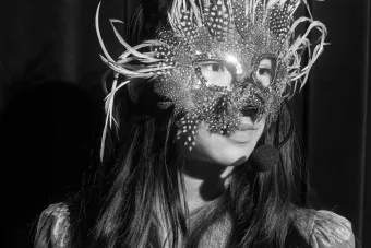 image of young girl wearing animal mask in black and white