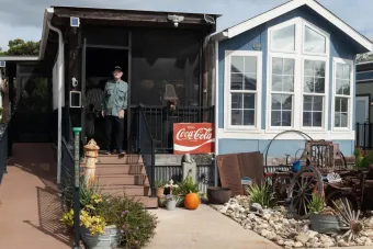 photograph of man standing outside his tiny home by Eli Durst