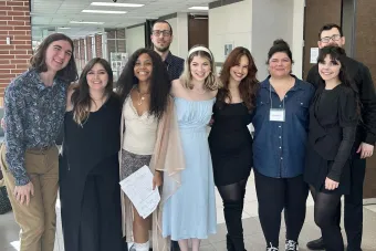 9 people standing in a school hallway