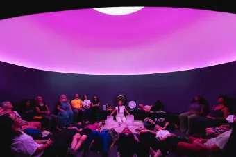A musician plays music on the floor of James Turrell's Skyspace The Color Inside at The University of Texas at Austin.