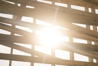 Sunlight shinning through slatted uneven wooden boards
