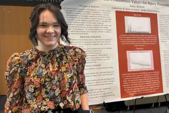 Sidney Becktold standing in front of a research poster