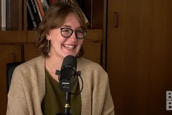 Chloe Yofan talking into a mic with a bookcase in the background