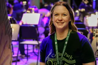 Lisa Holt looking at the camera with music stands in the background