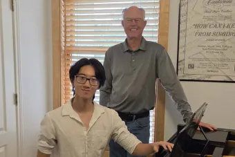 Jeffery Li and Charles Quereau stand in front of a piano