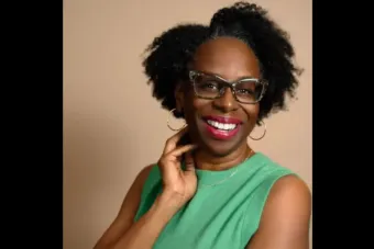 A woman in a green blouse smiles