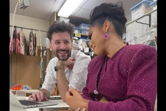 A man smiles at a woman wearing a purple costume