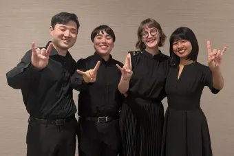 Soha, quartet composed of Mei Liu (violin), Chloe Yofan (violin), Thomas Gougeon (viola), and Katusaki Arakawa (cello) showing the hook em sign