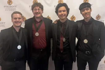 The members of 4116 Saxaphone quartet standing with medals around their neck
