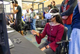 A student plays a game while wearing a VR headset