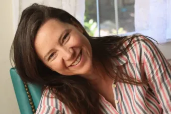 A woman with long brown hair smiles