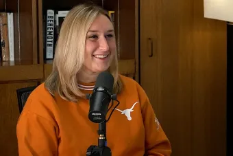 Marissa Guarriello talking into a mic with a bookshelf in the background