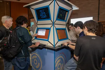 Students at audiopixelcollider play at a gaming station inspired by Armadillo World Headquarters design aesthetic