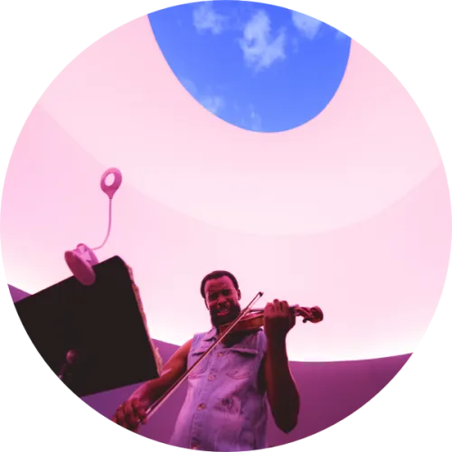 A musician plays a violin inside James Turrell's Skyspace at UT Austin