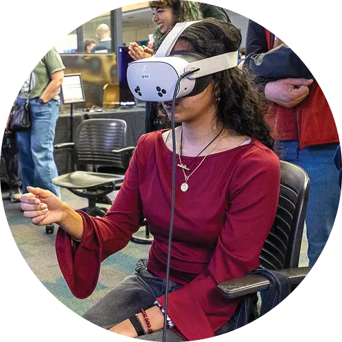 A student wearing a virtual reality headset while playing a VR game.