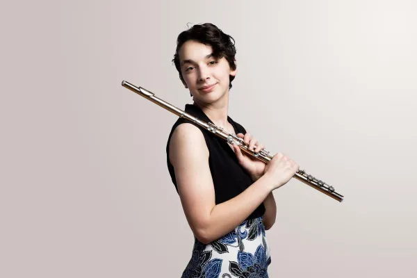 a student holds her flute over her shoulder.