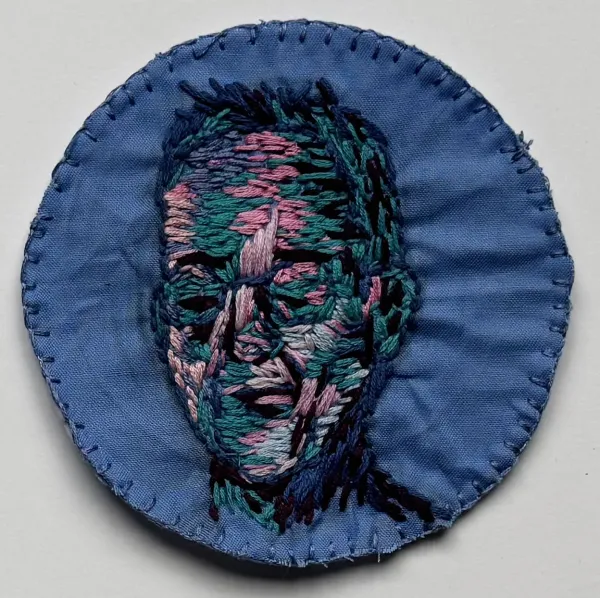 portrait of person rendered in different colored thread