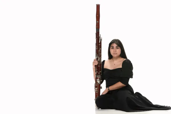 A headshot of Isabella Perez with her bassoon
