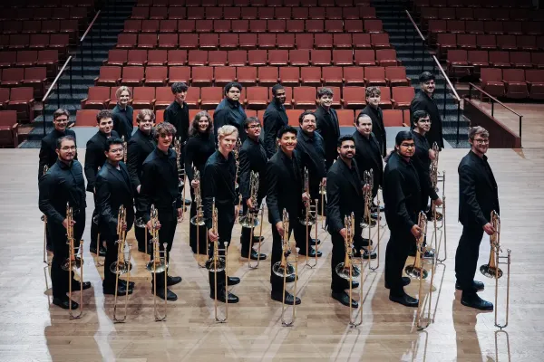 Trombone Choir on the stage of Bates Recital Hall with their trombones