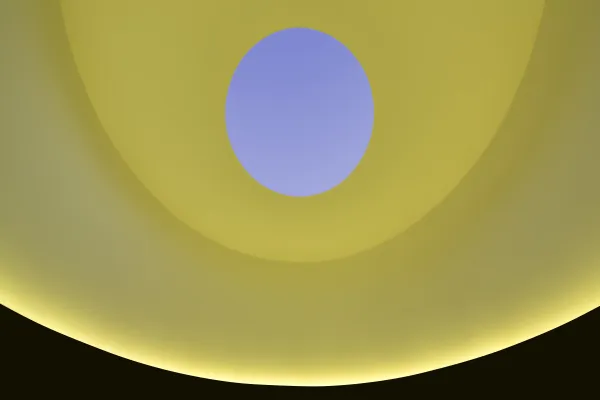 A curved room is lit yellow, while an open oculus in the ceiling reveals a lavender sky.
