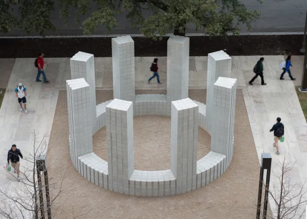 A large exterior sculpture made of cement, arranged in a circle with columns  