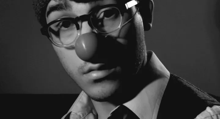 a portrait of robert didonato wearing a clown nose
