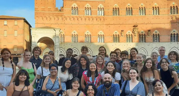 A group of students studying abroad in a piazza in Sienna