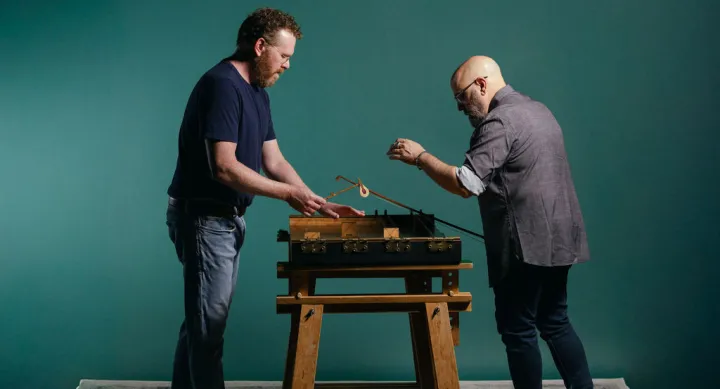Butler School of Music staff members Travis Weller and Andy Stoltz play an instrument Weller designed and built. Photo by Eani Creative