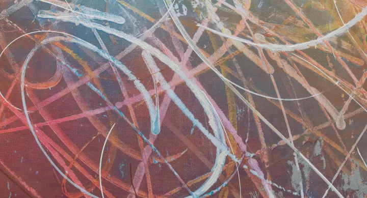 A close up of an abstract painting, featuring white scribbles across a rainbow gradient background.