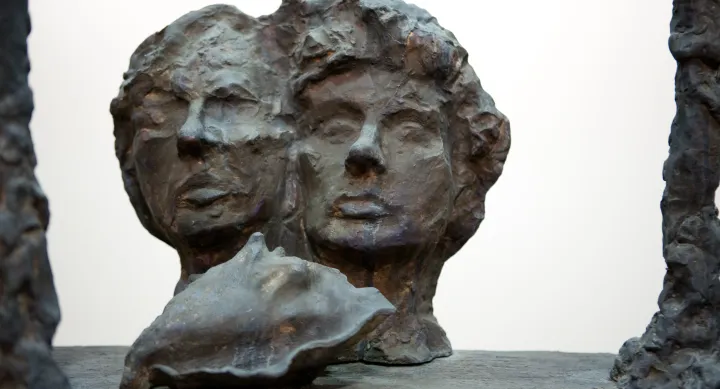 A bronze bust of two heads behind a bronze conch