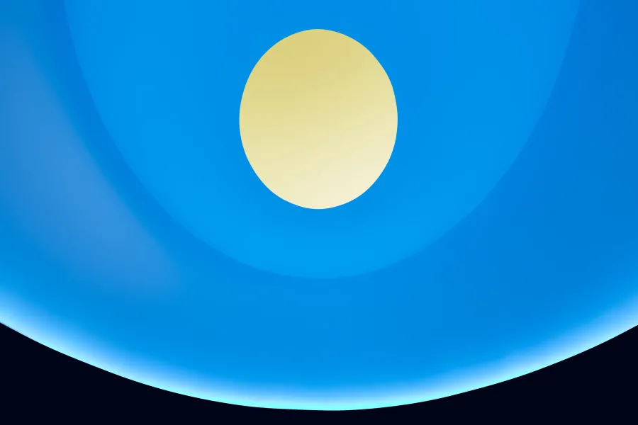A blue lit curved interior features a circular oculus at the top that opens to a yellow sky.