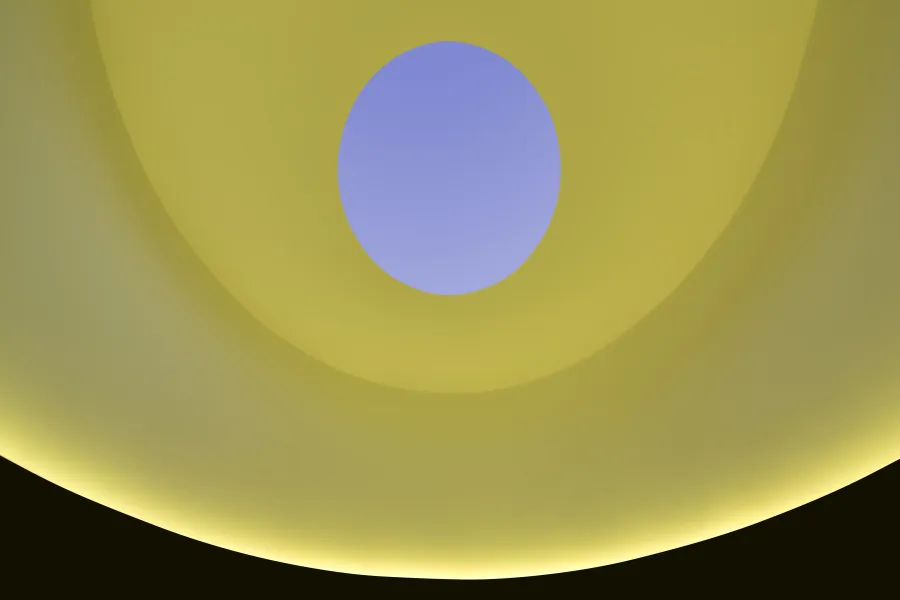 A curved room is lit yellow, while an open oculus in the ceiling reveals a lavender sky.