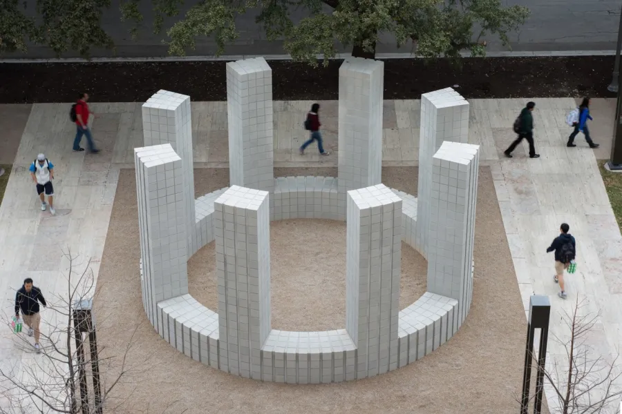 A large exterior sculpture made of cement, arranged in a circle with columns  