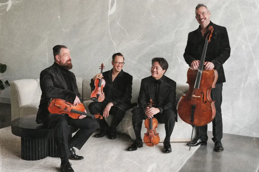 The Miro Quartet sit in a minimalist white room with their instruments